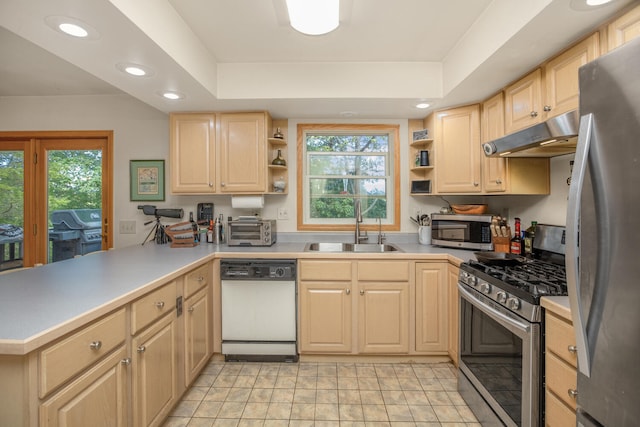 kitchen featuring light brown cabinets, under cabinet range hood, a sink, appliances with stainless steel finishes, and open shelves