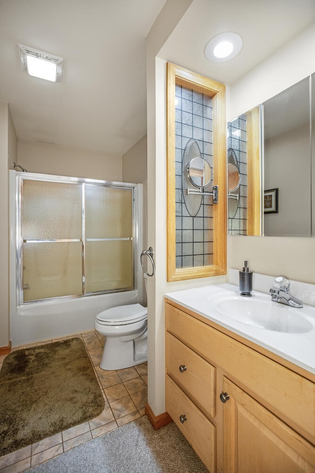 full bath featuring toilet, tile patterned flooring, enclosed tub / shower combo, and vanity