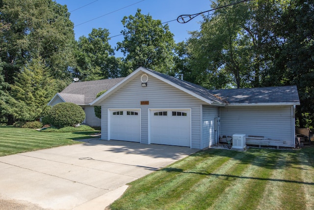 exterior space with a yard, concrete driveway, and an attached garage