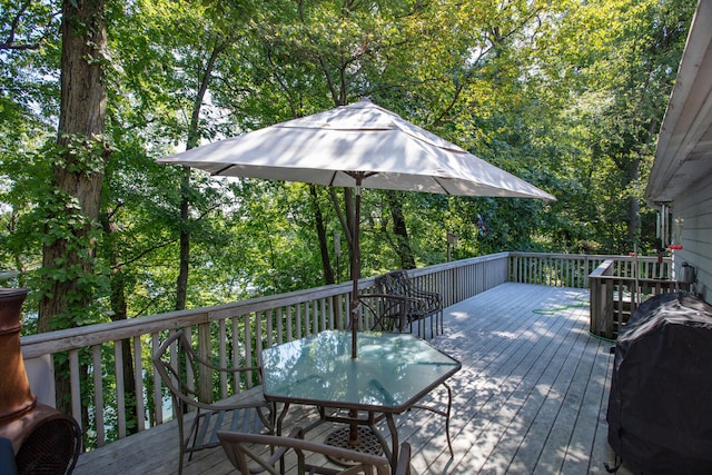 deck with outdoor dining space and a grill