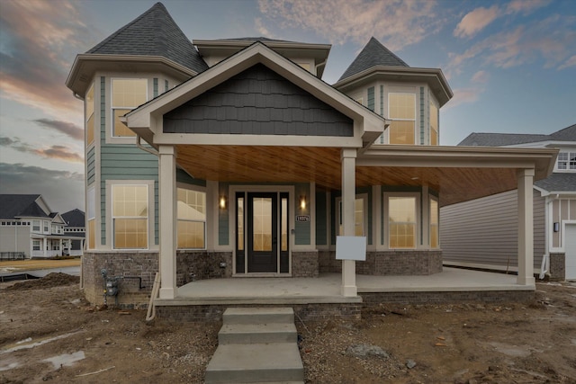 view of front of home featuring stone siding and a porch