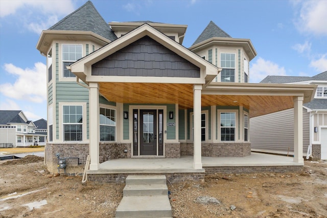 craftsman inspired home featuring a porch and a shingled roof