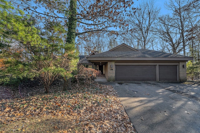 view of front of property with driveway, brick siding, and an attached garage