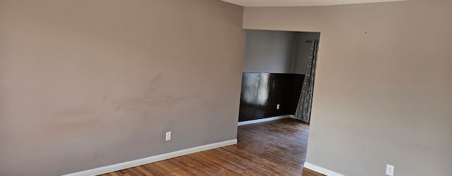 unfurnished room featuring baseboards and wood finished floors