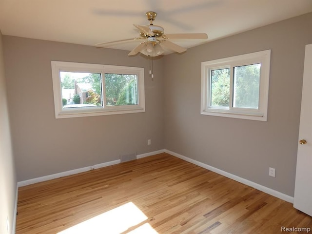 unfurnished room with plenty of natural light, visible vents, and baseboards