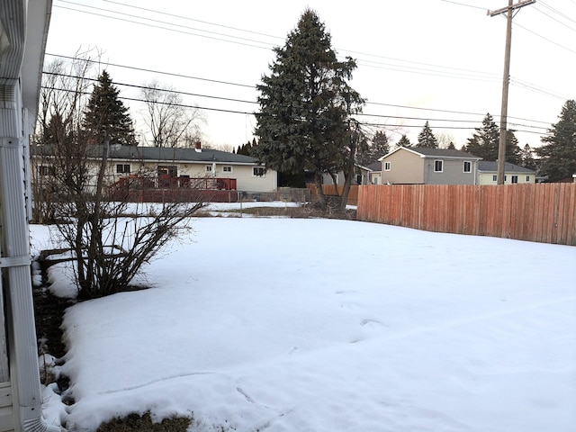 snowy yard featuring fence