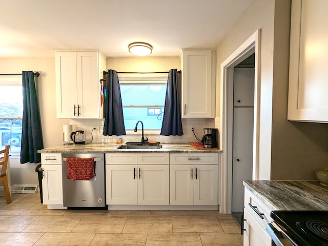 kitchen with a sink, light stone counters, white cabinets, and dishwasher