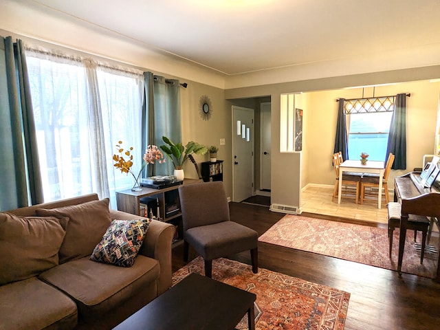 living room with a healthy amount of sunlight, baseboards, and wood finished floors