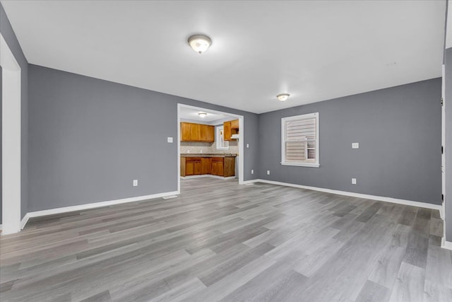 unfurnished living room featuring light wood-style floors and baseboards