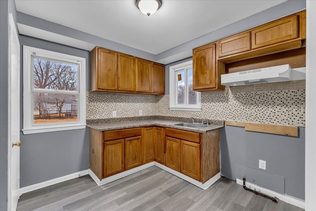 kitchen with under cabinet range hood, plenty of natural light, and decorative backsplash