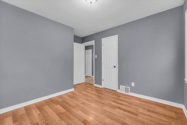 unfurnished bedroom with light wood-type flooring, visible vents, and baseboards