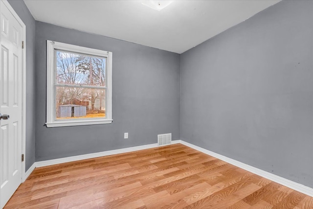 unfurnished room with baseboards, visible vents, and light wood finished floors