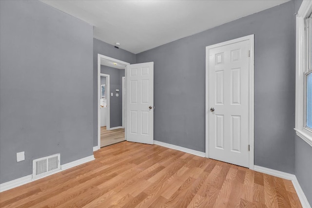 interior space featuring baseboards, visible vents, and light wood-style floors