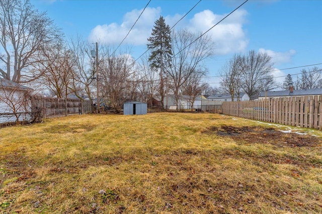 view of yard with a fenced backyard, a shed, and an outdoor structure