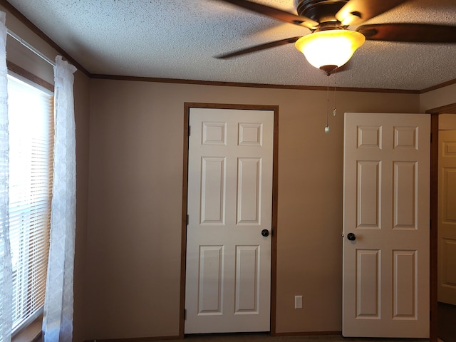 unfurnished bedroom featuring crown molding, a textured ceiling, and ceiling fan