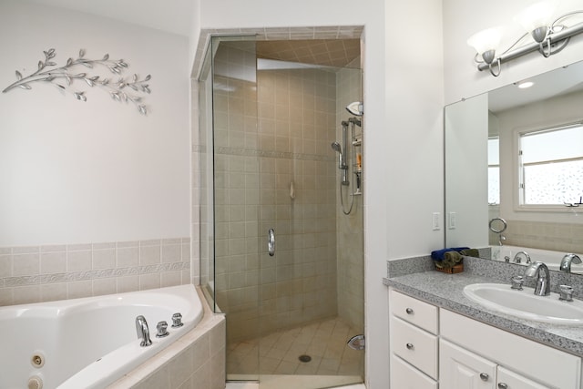 full bath with a whirlpool tub, a shower stall, and vanity