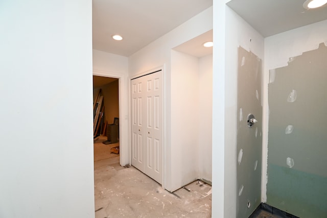 hallway featuring recessed lighting and unfinished concrete flooring