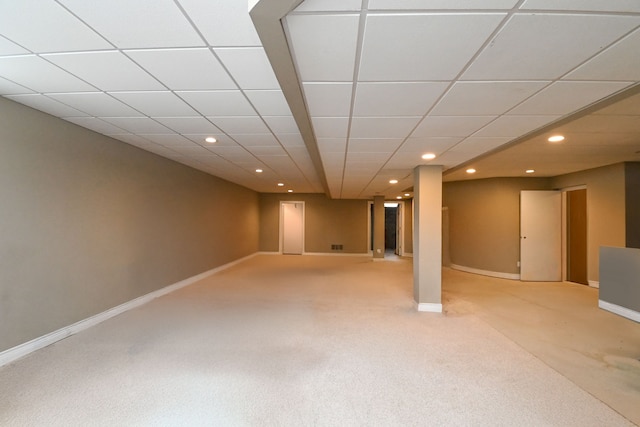 finished below grade area featuring recessed lighting, light colored carpet, a paneled ceiling, and baseboards