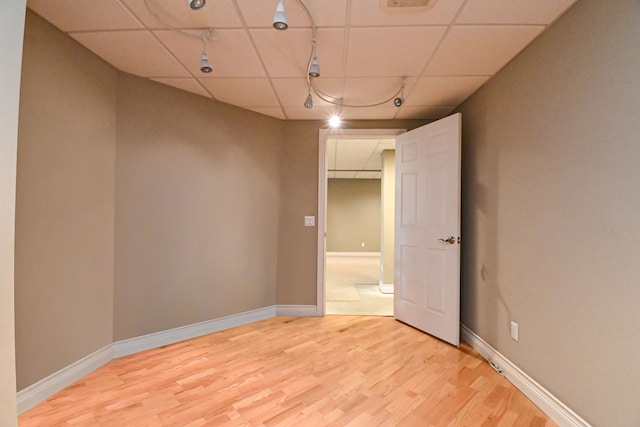 spare room with light wood-type flooring and a drop ceiling