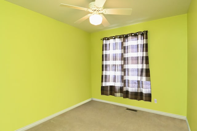 spare room featuring a ceiling fan, carpet flooring, visible vents, and baseboards