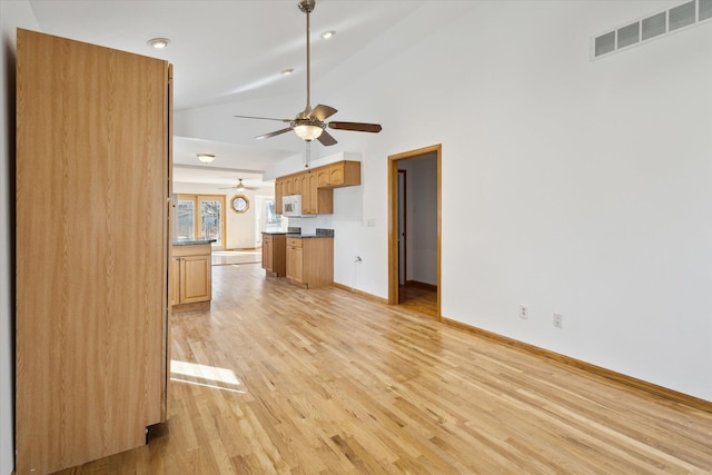 unfurnished living room featuring visible vents, light wood-style floors, ceiling fan, high vaulted ceiling, and baseboards