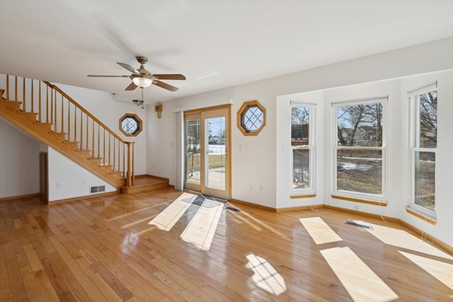 entryway with baseboards, visible vents, light wood finished floors, and stairs