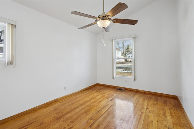 unfurnished room with lofted ceiling, ceiling fan, visible vents, baseboards, and light wood finished floors