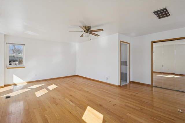 unfurnished bedroom featuring a closet, visible vents, light wood-style flooring, a ceiling fan, and baseboards