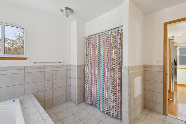 bathroom with wainscoting, tile walls, and tile patterned floors