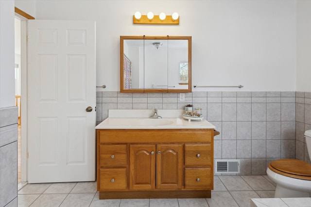 full bath with toilet, tile walls, visible vents, and tile patterned floors