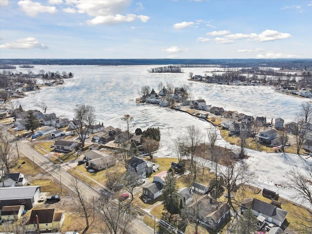 snowy aerial view with a residential view and a water view