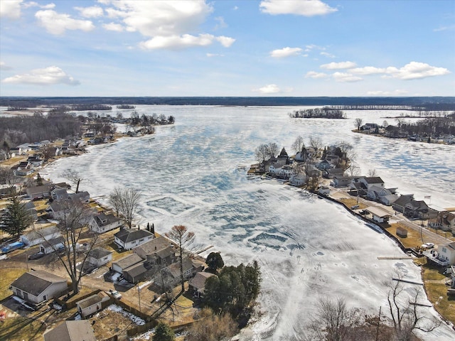 snowy aerial view featuring a water view and a residential view