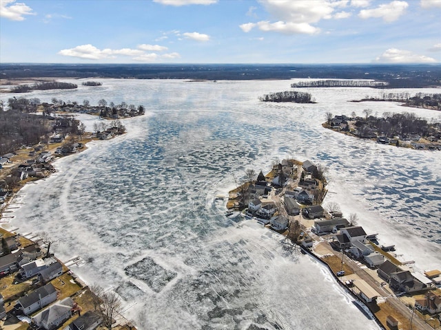 snowy aerial view with a water view and a residential view