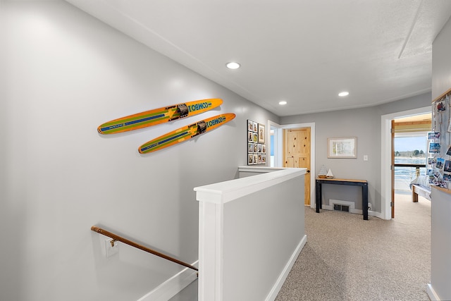 hall featuring visible vents, baseboards, carpet flooring, an upstairs landing, and recessed lighting