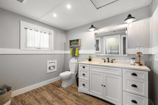 bathroom with vanity, wood finished floors, toilet, and baseboards