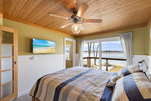 bedroom featuring carpet, wood ceiling, a ceiling fan, and wainscoting