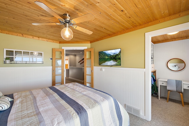 carpeted bedroom with wooden ceiling, visible vents, and wainscoting