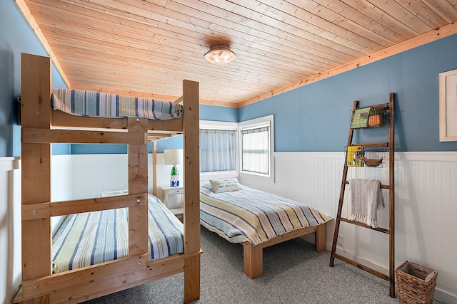 carpeted bedroom with wooden ceiling and wainscoting