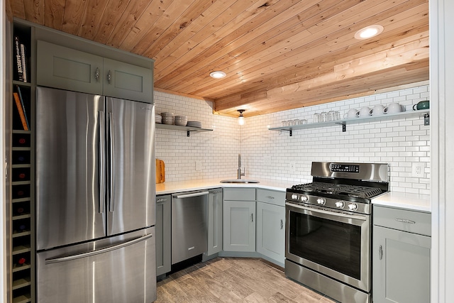 kitchen featuring a sink, light countertops, appliances with stainless steel finishes, backsplash, and open shelves