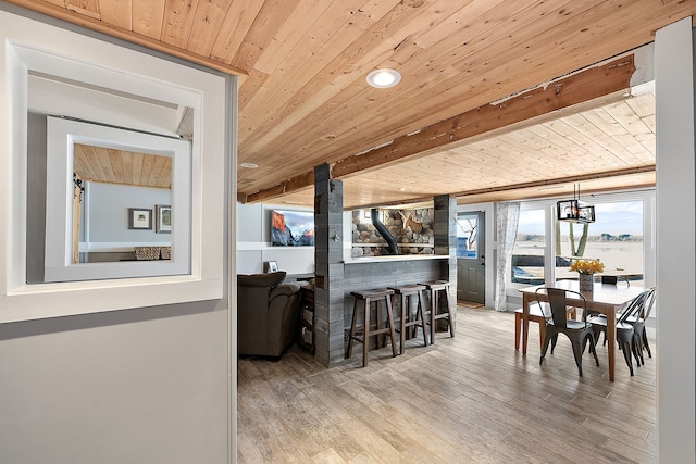 interior space featuring light wood-type flooring, wooden ceiling, pendant lighting, and beam ceiling