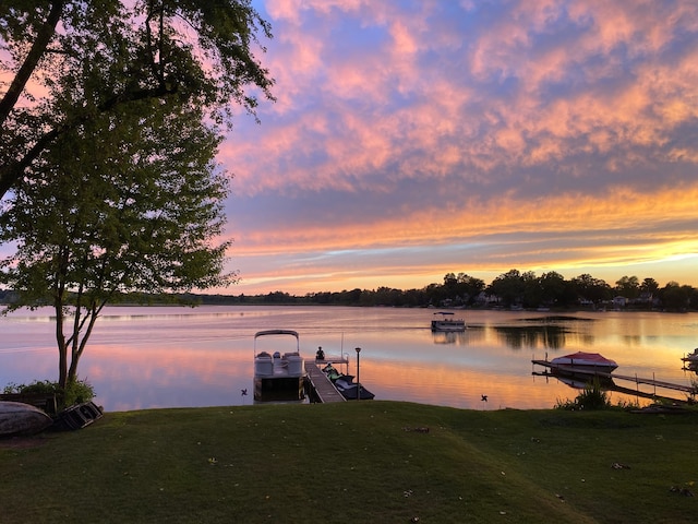 dock area with a water view and a lawn