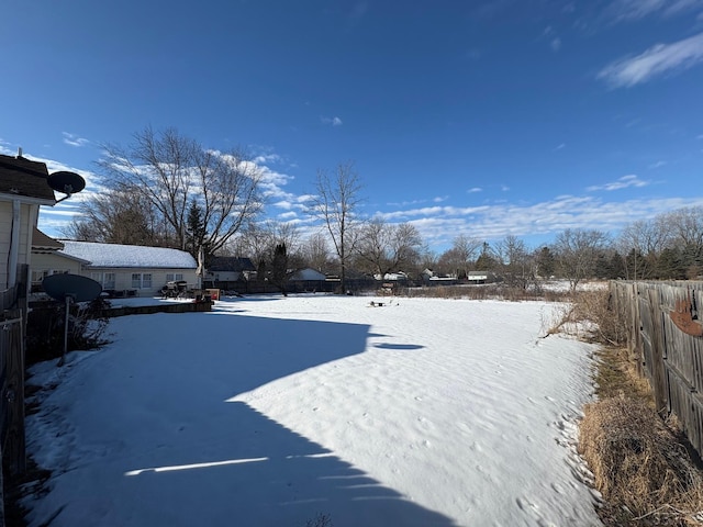 snowy yard featuring fence