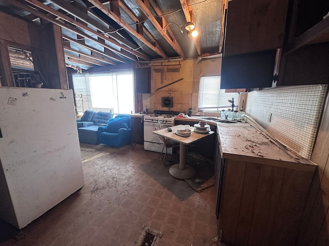 kitchen with white appliances, plenty of natural light, light countertops, and a sink