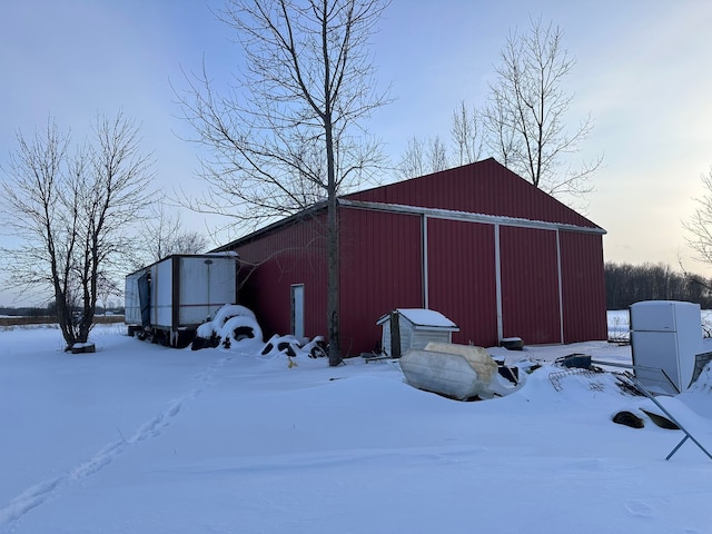 snow covered structure with an outdoor structure and an outbuilding