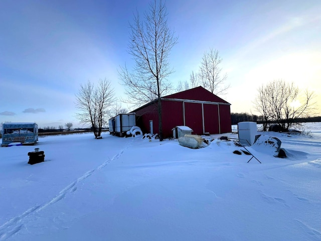 snowy yard featuring an outbuilding