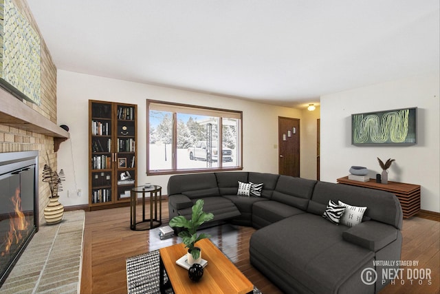 living room with a fireplace, wood finished floors, and baseboards