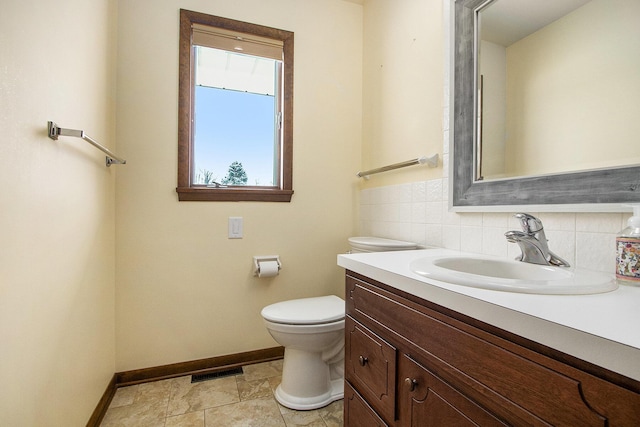 bathroom with visible vents, decorative backsplash, toilet, vanity, and baseboards