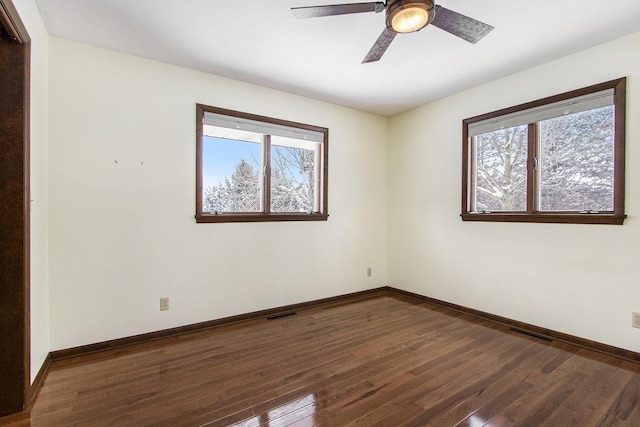 empty room featuring baseboards, visible vents, ceiling fan, and wood finished floors