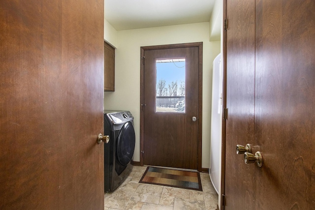 clothes washing area featuring cabinet space, baseboards, and separate washer and dryer