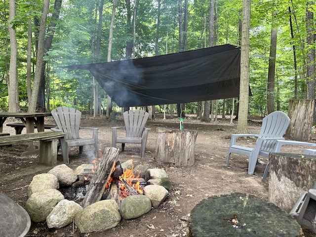 view of patio / terrace featuring a fire pit and a forest view